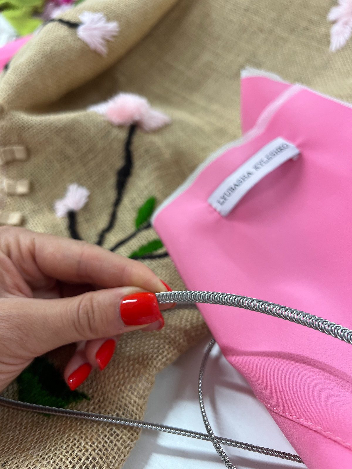 Detalle del forro rosa y la ballena metálica utilizados en la estructura interior de un corsé de arpillera.