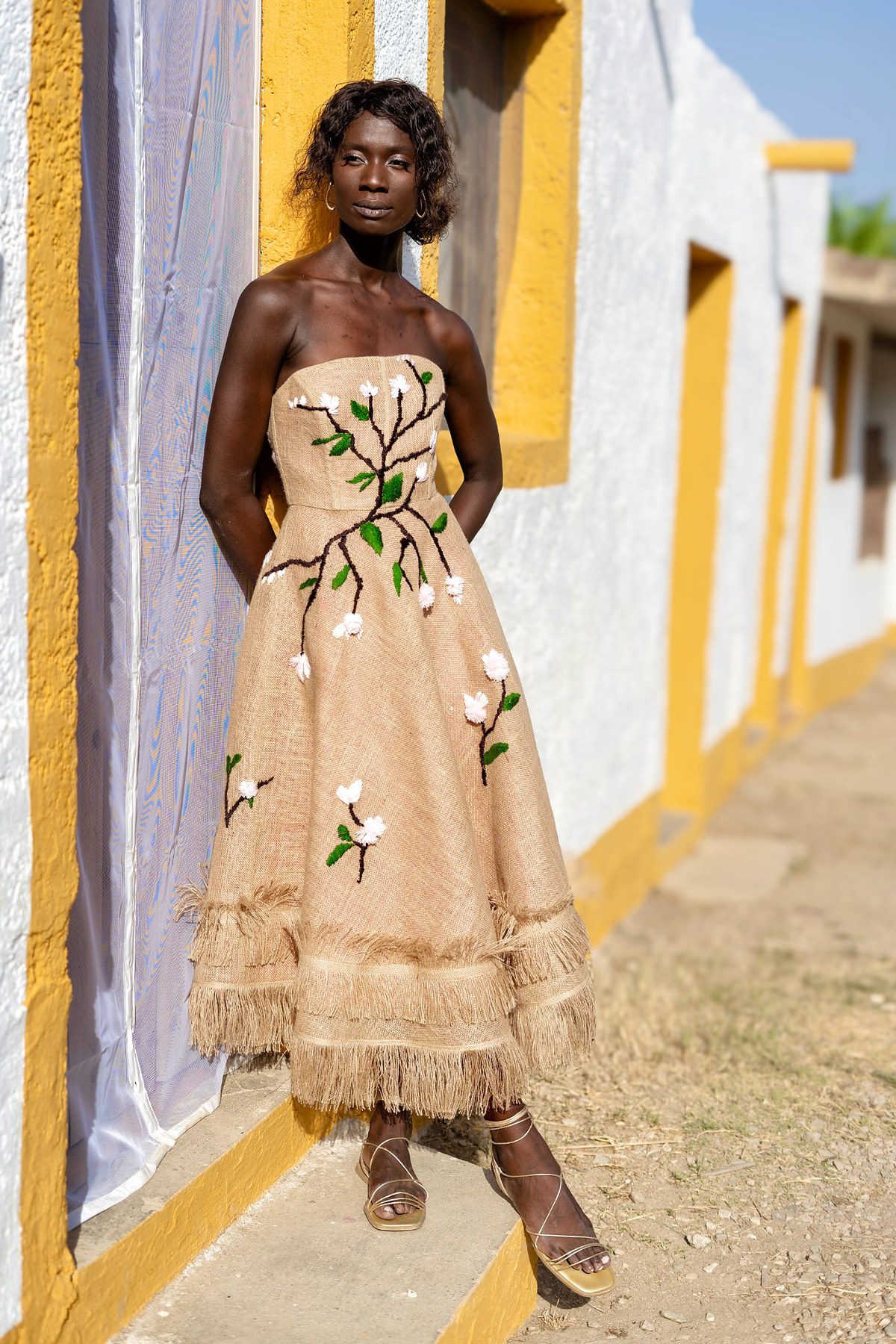 Vestido largo de arpillera con bordado de ramas y flores inspirado en el almendro en flor.