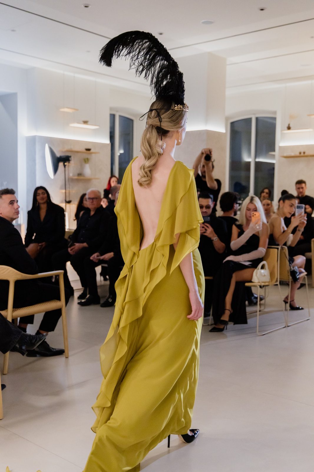 Modelo de espaldas con vestido largo lima, escote profundo en la espalda y volantes fluidos.